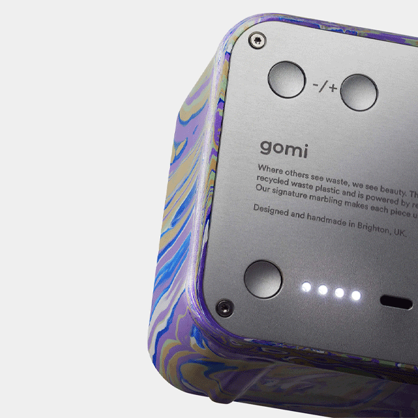 Close-up of a bluetooth speaker with 'gomi' branding and marbled design.