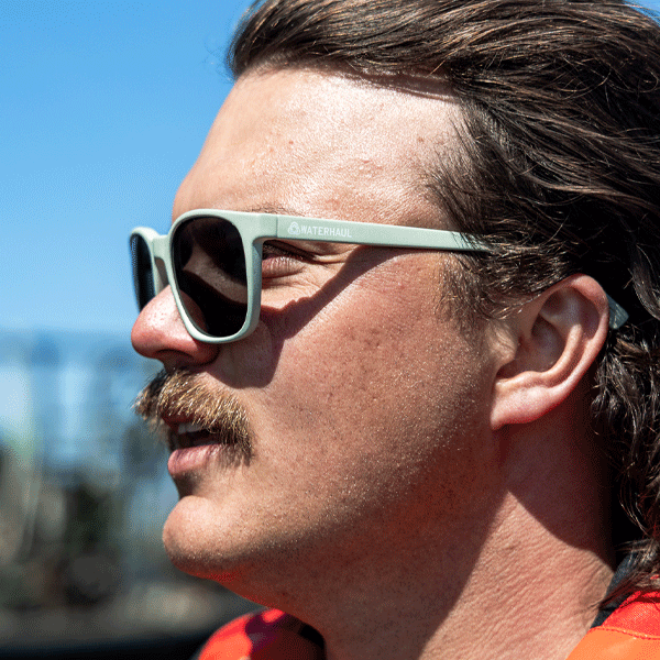 Man wearing green sunglasses with a nautical background