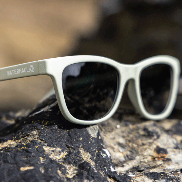 Sunglasses with 'Waterhaul' branding on a rocky surface