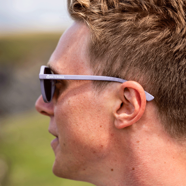 Close-up of a person wearing sunglasses with a blurred natural background