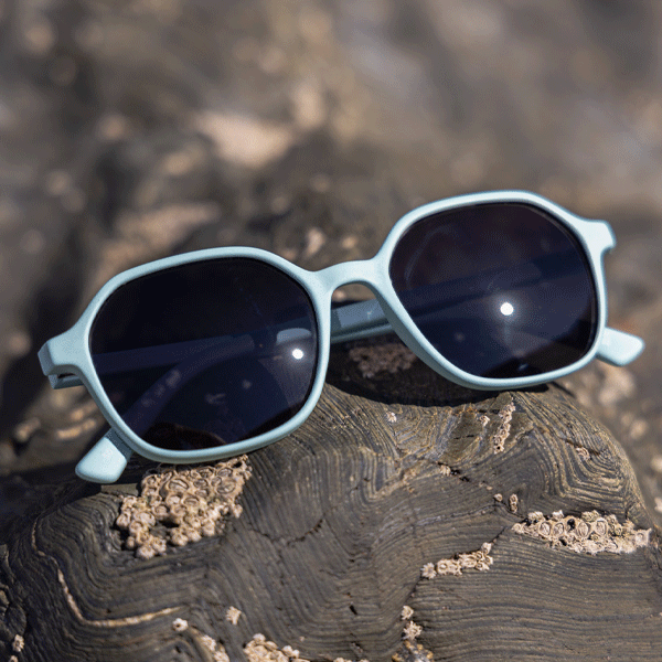 Light blue sunglasses against a rocky background