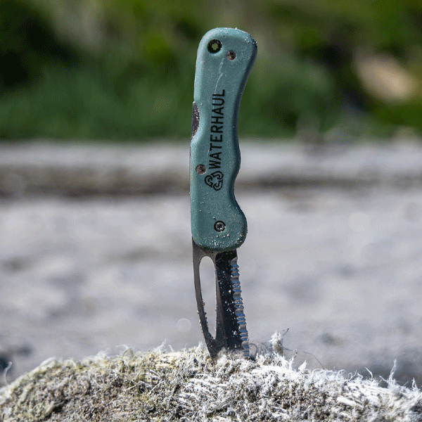 Pocket knife with green hand an Waterhaul branding in a fishing rope