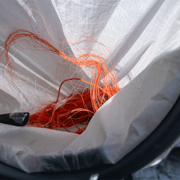 Close-up of orange fishing line in a white bin bag