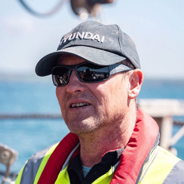 Man wearing a cap and sunglasses with a blurred background