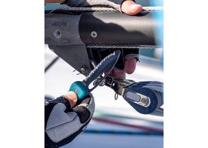 Pocket knife with turquoise handle being used as shackle key on a sailing boat.